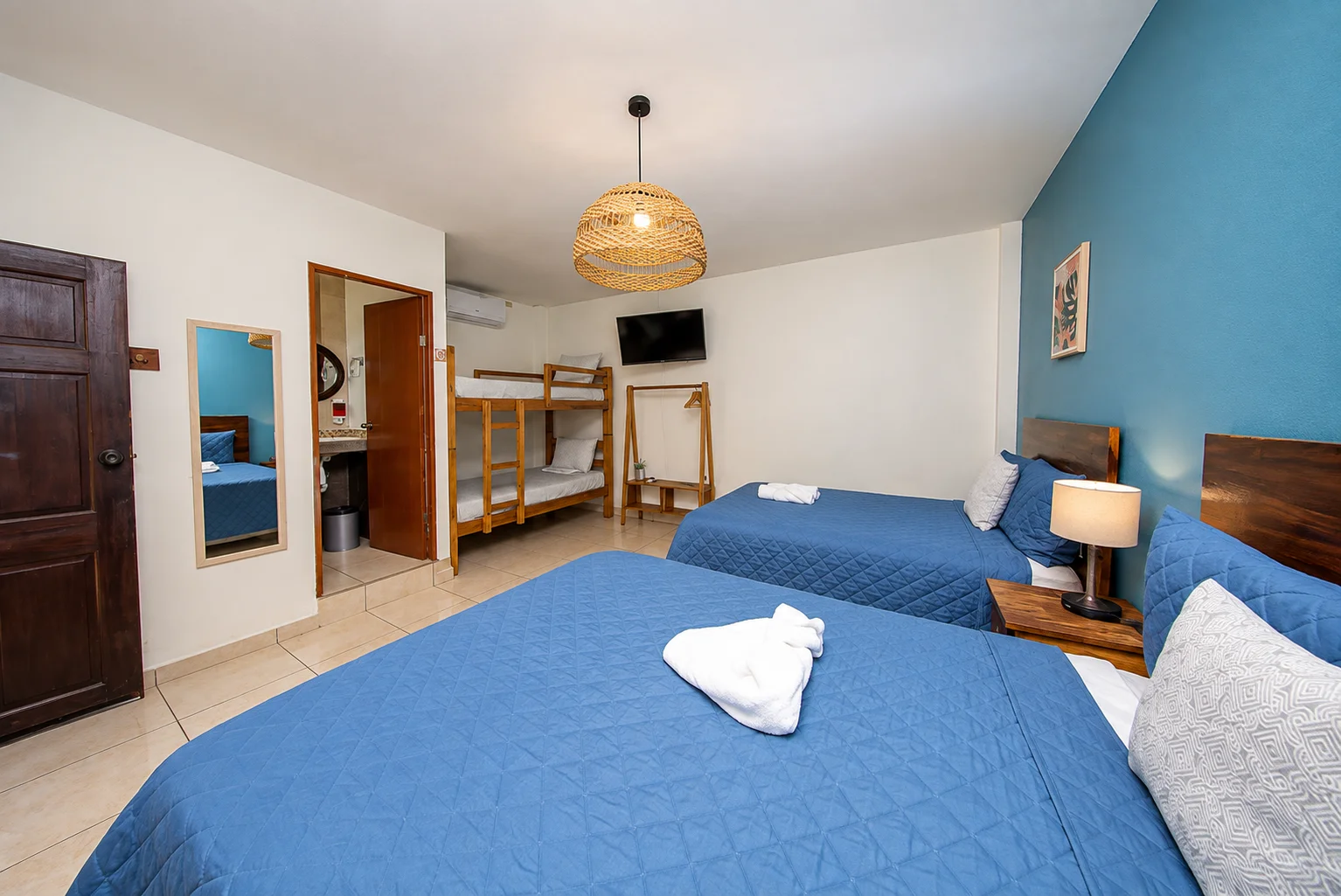 Habitación Doble de Mi Costa Vida, con dos camas y pared azul de acento
