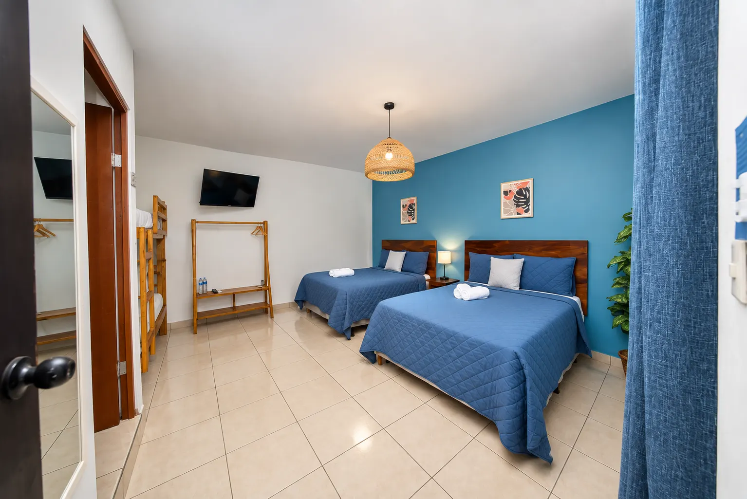 Habitación Familiar de Mi Costa Vida, con camas y pared azul