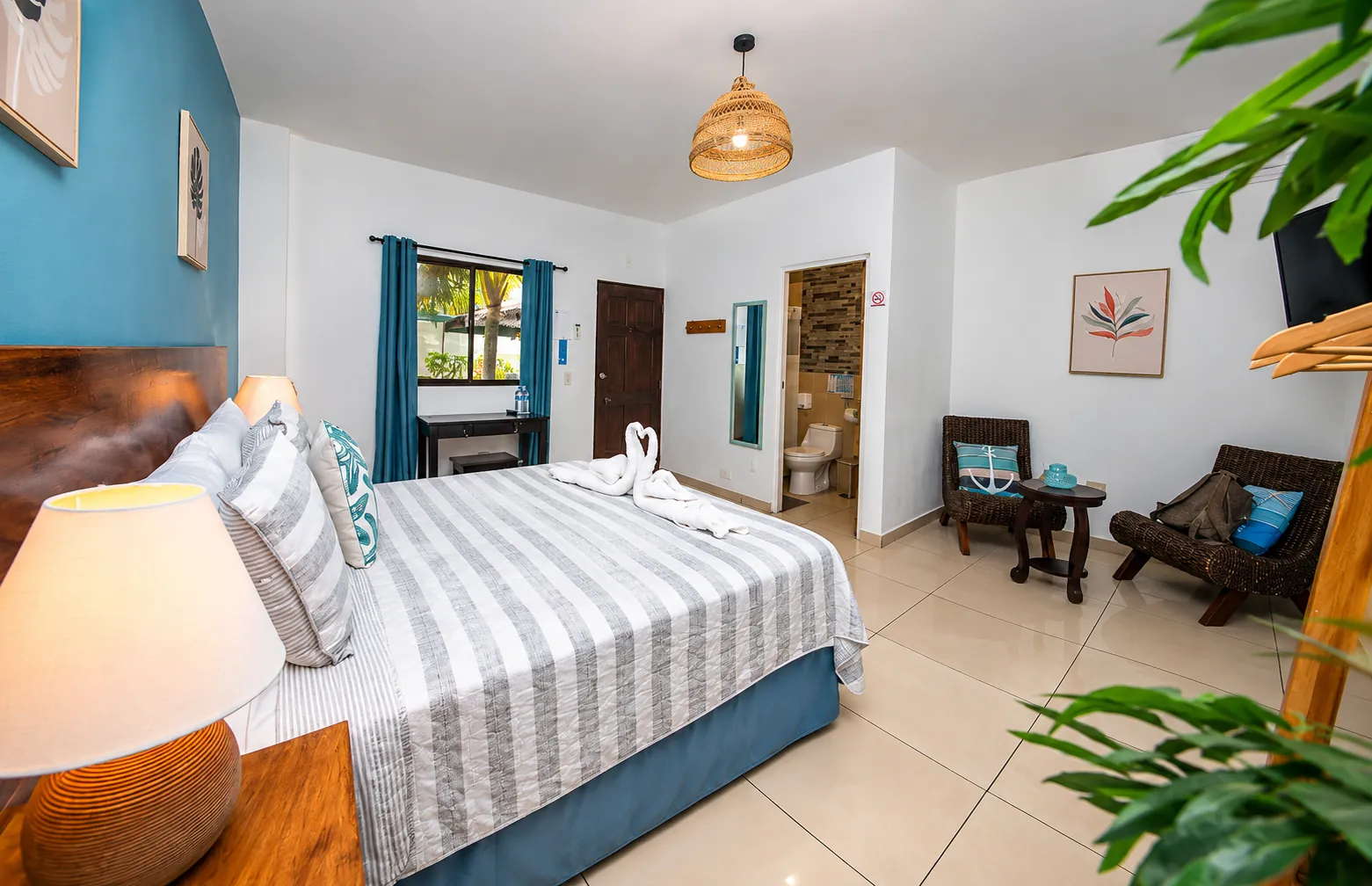 Habitación Queen de Mi Costa Vida, con pared azul y toallas en forma de cisne