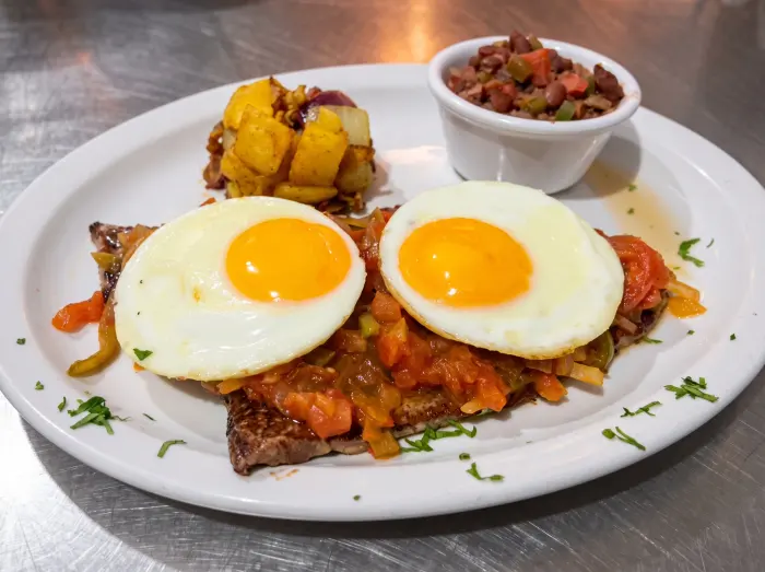 Carne con huevos estrellados y salsa criolla